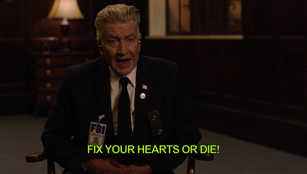 David Lynch's character sits in a chair wearing a suit with an FBI ID tag on it and he leans forward slightly shouting. The subtitle says "FIX YOUR HEARTS OR DIE!"