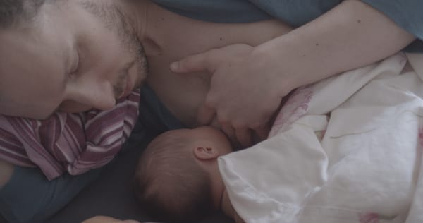 An image of a father breastfeeding his child.