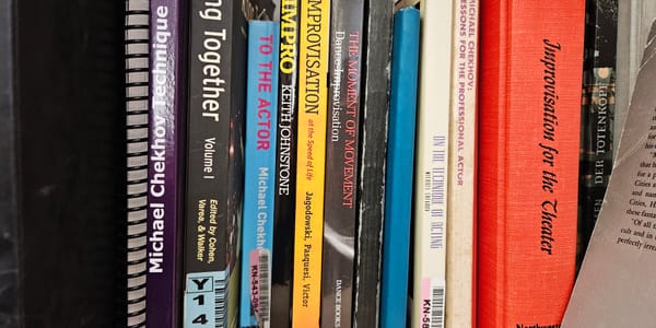 Photo of bookshelf showing spines of books on acting and improvisation.